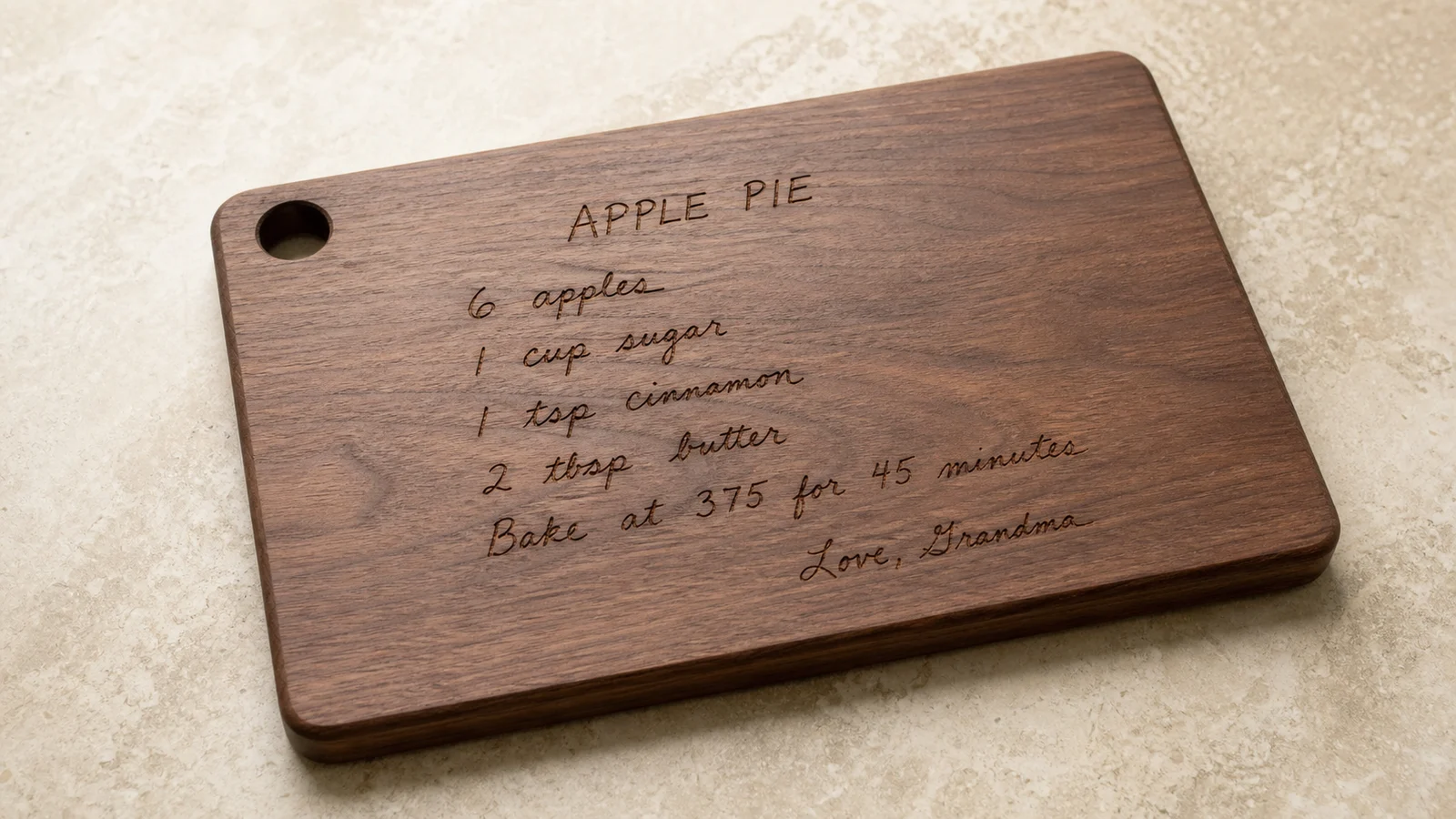 Handwritten apple pie recipe laser engraved on a walnut cutting board